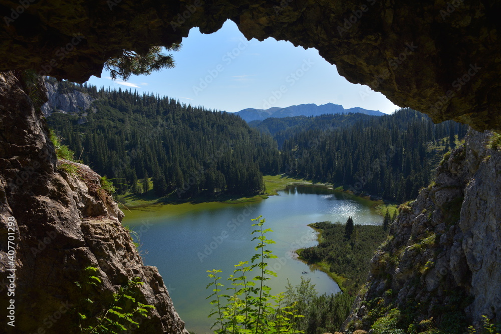 View of a lake in the mountains from a cave