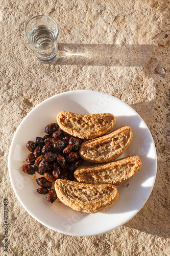 Cretan rusks, olives and tsikoudia (raki), a delicious snack meal as often offered in Crete. All three products are of typical Cretan cuisine. photo