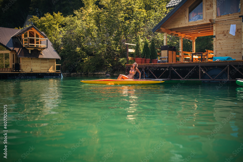 Obraz premium Lady paddling the kayak at the calm lake