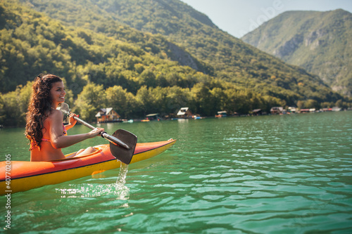 Young woman canoeing in a lake on a summer day.