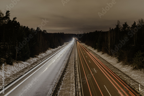 Fototapeta Long exposure of a road with light trails of passing vehicles