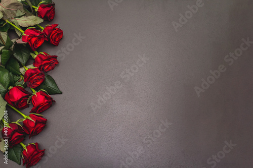 Bouquet of fresh burgundy roses on a black stone concrete background