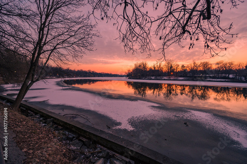 Obraz na płótnie Colourful sunset over frozen lake in city park during cold winter evening w salonie
