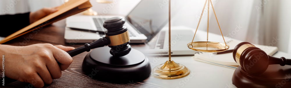 Business and lawyers discussing contract papers with brass scale on desk in office. Law, legal services, advice, justice and law concept picture with film grain effect Business and lawyers discussing contract papers with brass scale on desk in office. Law, legal services, advice, justice and law concept picture with film grain effect
