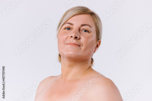 Portrait of a senior contented woman with clean and fair skin on a white background. A natural beauty concept.