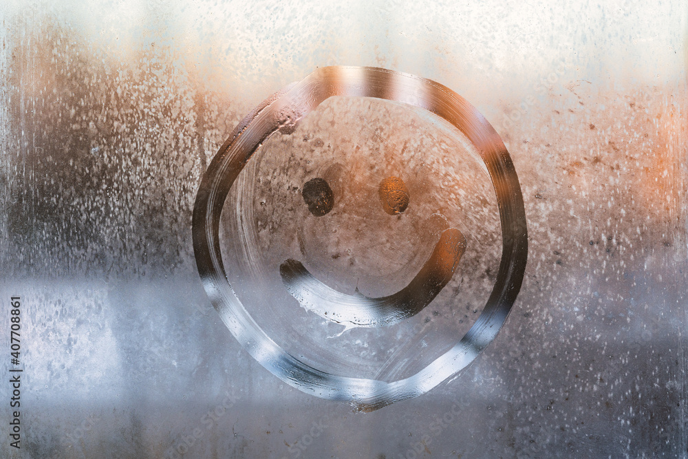 Smiley face drawn on a frozen window