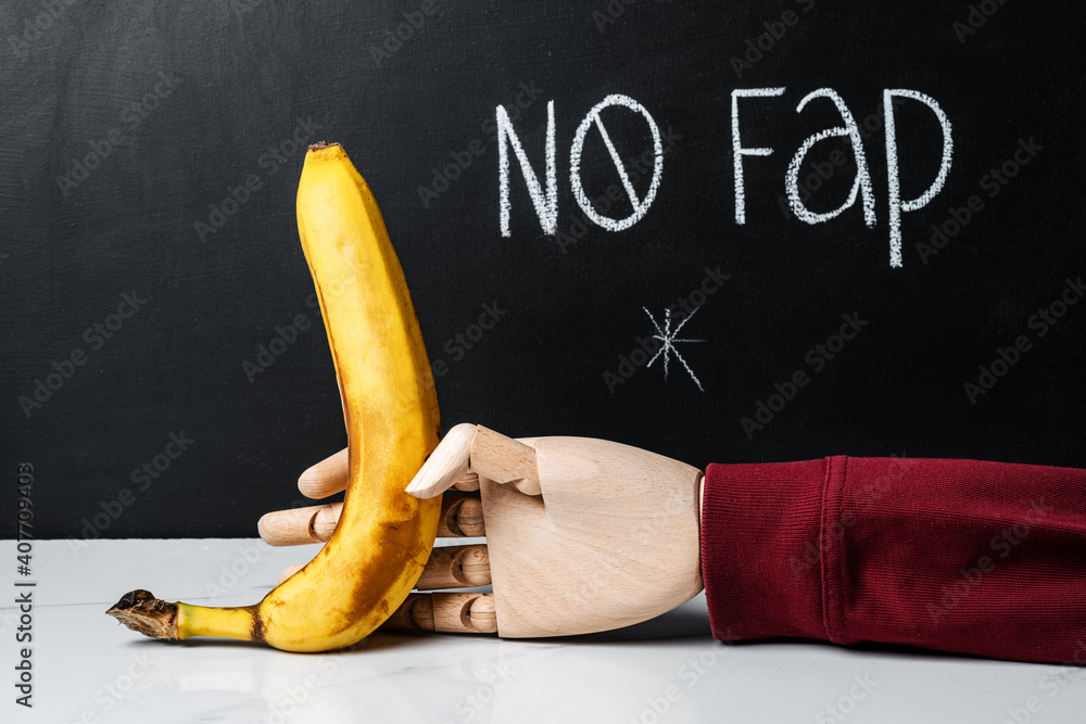 Inscription on chalkboard No fap and a hand holding a banana