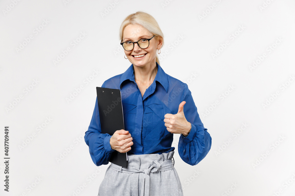 Blonde successful smiling confident business woman 40s wearing blue shirt glasses formal clothes clipboard with papers document show thumb up like gesture isolated on white background studio portrait Blonde successful smiling confident business woman 40s wearing blue shirt glasses formal clothes clipboard with papers document show thumb up like gesture isolated on white background studio portrait