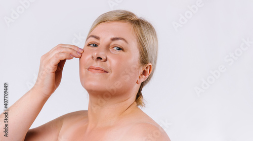 Banner,long format. Blond woman with moisturized, clean and shiny skin on a white background with empty side advertising space.