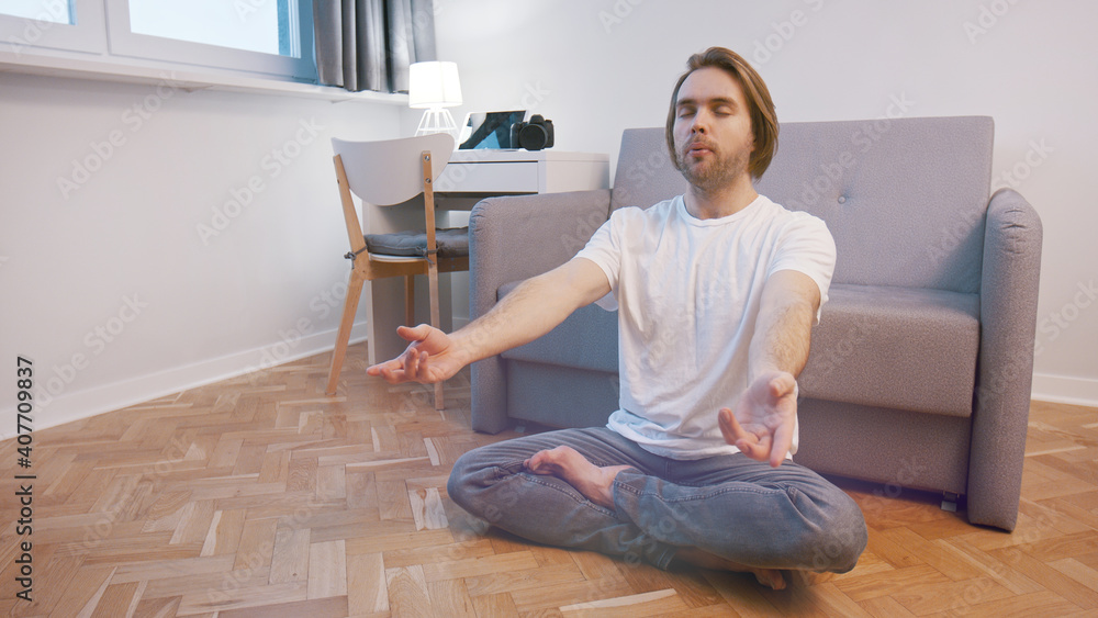 Young caucasian man meditating in his appartment. Mental clarity and wellbeing concept. High quality photo Young caucasian man meditating in his appartment. Mental clarity and wellbeing concept. High quality photo
