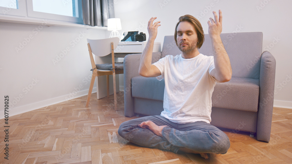 Young caucasian man meditating in his appartment. Breathing technique. High quality photo Young caucasian man meditating in his appartment. Breathing technique. High quality photo