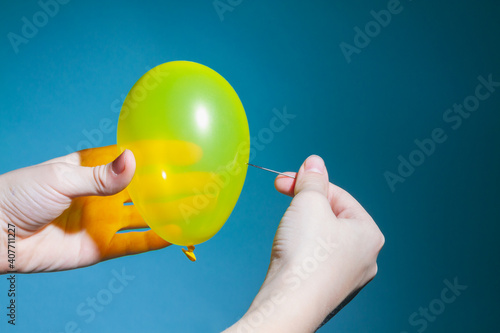 Pierce or pop a yellow balloon with a needle on a blue background.