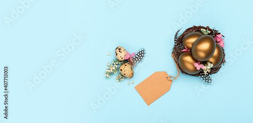 Easter Decoration with golden eggs, quail feathers, dried flowers on blue background. Happy Easter card concept.