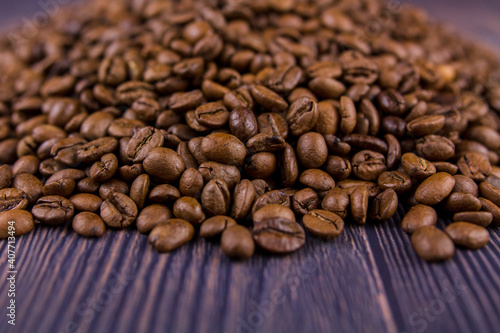 many coffee beans lie on a wooden table