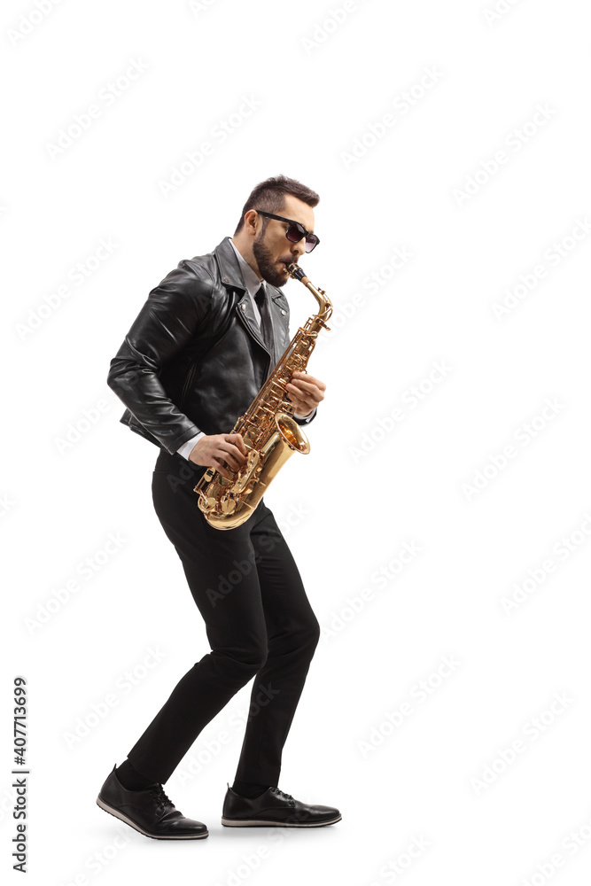 Fototapeta premium Full length profile shot of a man in a leather jacket playing a saxophone