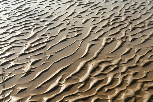 close up view of sand structures at low tide on a beach