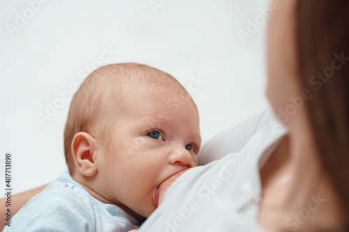 Close-up portrait of a child sucking milk from its mother's breast.