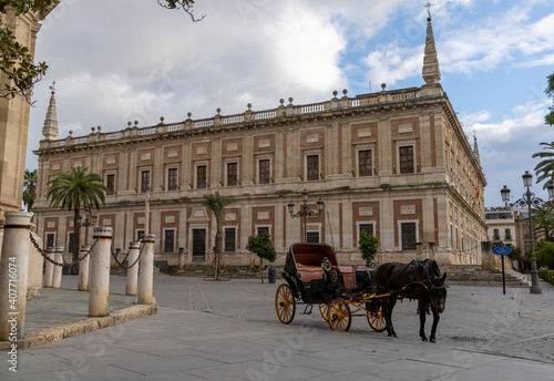 empty horse-drawn carriage waits for tourists at the Plaza del Triunfo Square for tourists