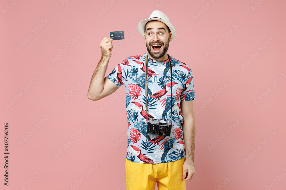Surprised young traveler tourist man in summer clothes hat hold credit bank card isolated on pink background studio portrait. Passenger travel abroad on weekends getaway. Air flight journey concept. Surprised young traveler tourist man in summer clothes hat hold credit bank card isolated on pink background studio portrait. Passenger travel abroad on weekends getaway. Air flight journey concept.
