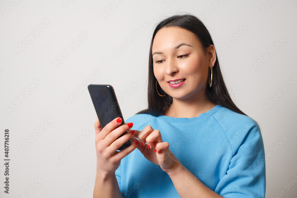 Young woman using a smartphone on white Young woman using a smartphone on white