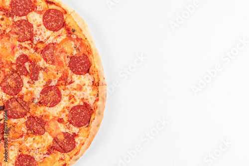 fresh aromatic hot italian pepperoni pizza with mozzarella cheese on white wooden table background