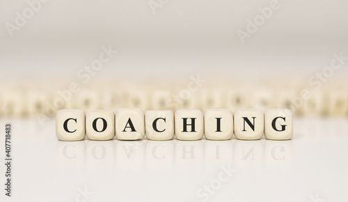Word COACHING written on wood block. Business concept.