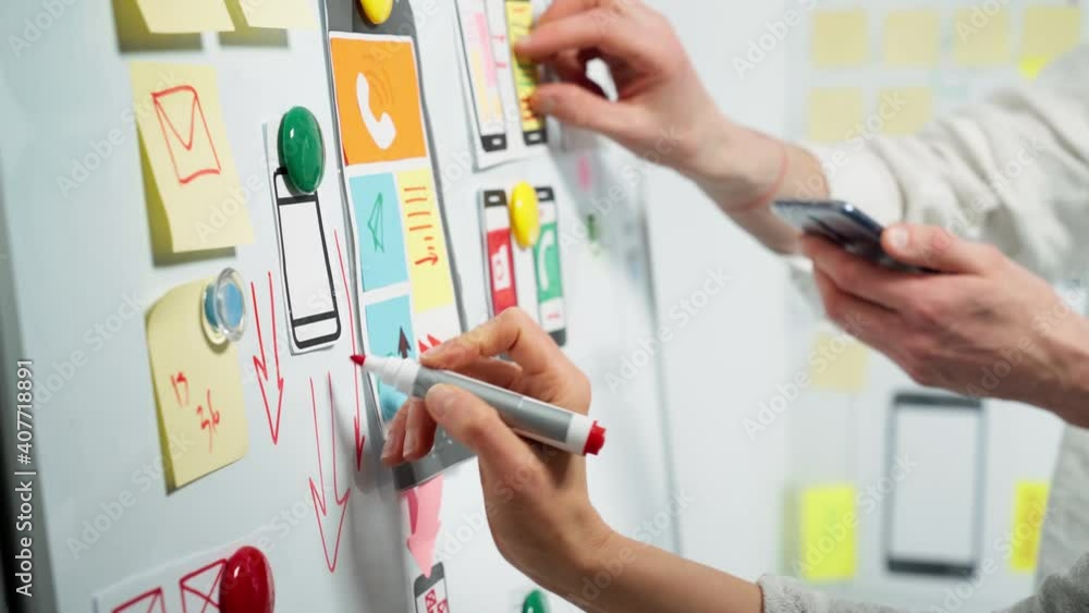 Mobile phone app developers create sketches. Website designers are working on the project interface.