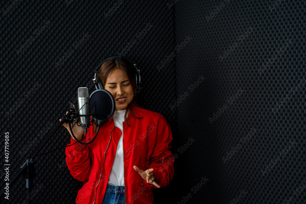 Asian woman singer wearing red shirt rehearsal musical performance in recording studio with microphone Asian woman singer wearing red shirt rehearsal musical performance in recording studio with microphone