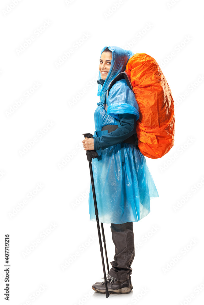 girl with hiking equipment and large backpack, wearing blue raincoat, posing in studio isolated on white girl with hiking equipment and large backpack, wearing blue raincoat, posing in studio isolated on white