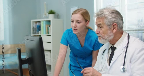 Wallpaper Mural Beautiful young female nurse talking to male doctor, using computer in hospital office. Medical workers discussing reports and looking at camera. Pandemic, medicine, healthcare concept. Torontodigital.ca