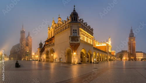 Krakow, Poland, main square night panorama with Cloth Hall and St Mary's church in the fog