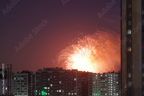 Beautiful fireworks above city roofs at nights. High quality photo