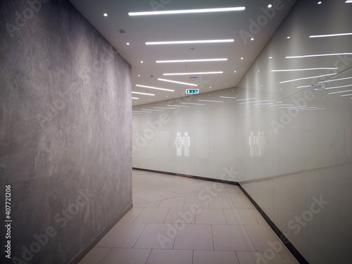 Fototapeta Naklejka Na Ścianę i Meble -  Access to the toilet with male and female figures on the marble wall. Copy space. No people