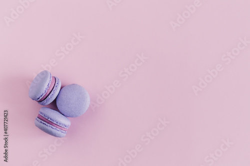 Tasty french macarons on a pink pastel background. Violet macarons.