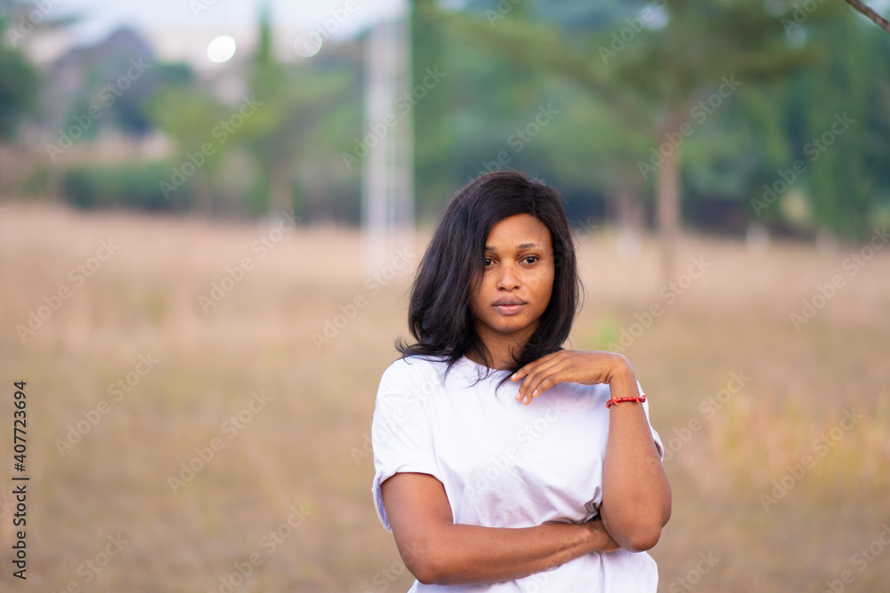 portrait of a young african woman standing in a park portrait of a young african woman standing in a park