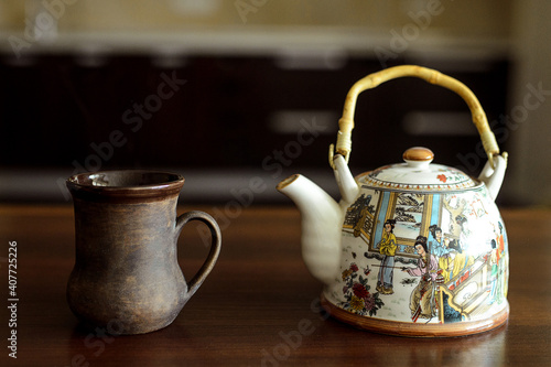 A table on which there is a mug of tea and a kettle.