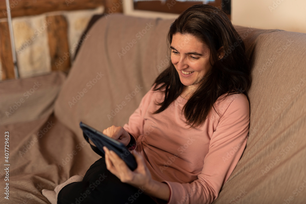 woman with a tablet sitting on a sofa woman with a tablet sitting on a sofa