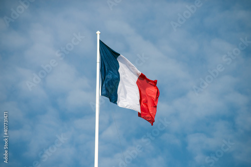 Bild auf Leinwand Closeup of french flag floating on blue sky background