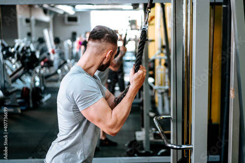 Muscular man working out arms biceps at gym. Fitness life, healthy life concept