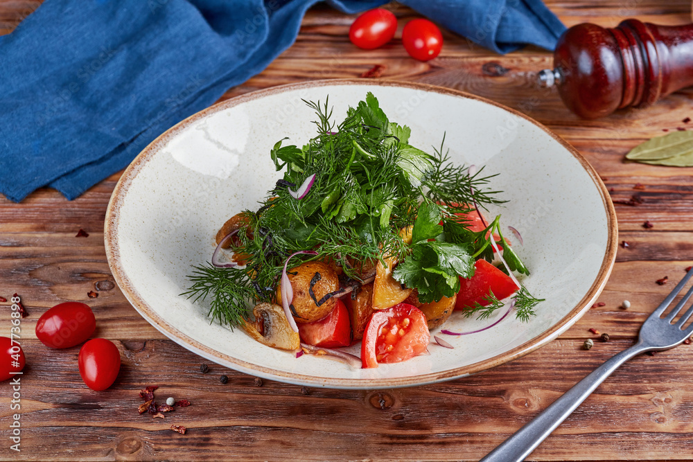 Fresh vegetable salad with baked potatoes and mushrooms, wooden background