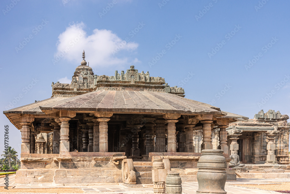 Lakkundi, Karnataka, India - November 6, 2013: Brown stone Mandapam of Brahma Jinalaya temple under blue cloudscape.