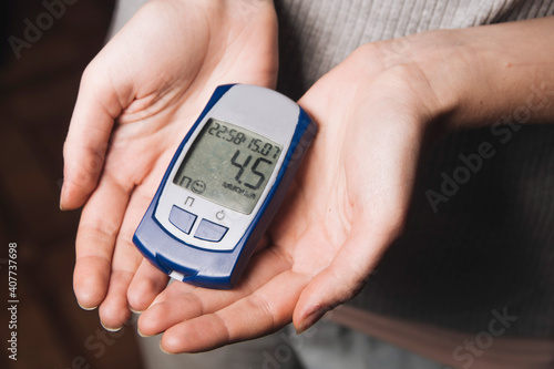 a person holds a blood glucose meter in his hands