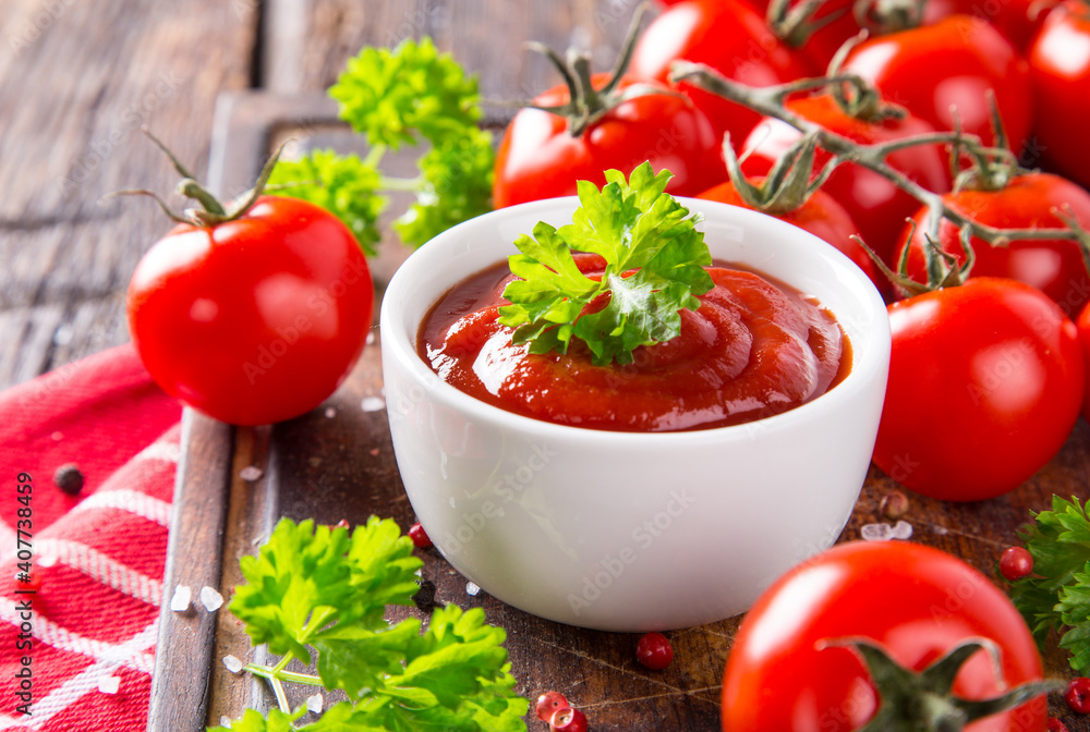 bowl of ketchup or tomato sauce and fresh tomatoes on wood table bowl of ketchup or tomato sauce and fresh tomatoes on wood table