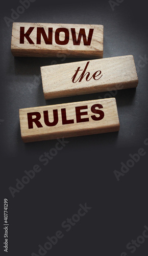 Know the rules word on wooden blocks isolated on dark grey background. business process regulation concept