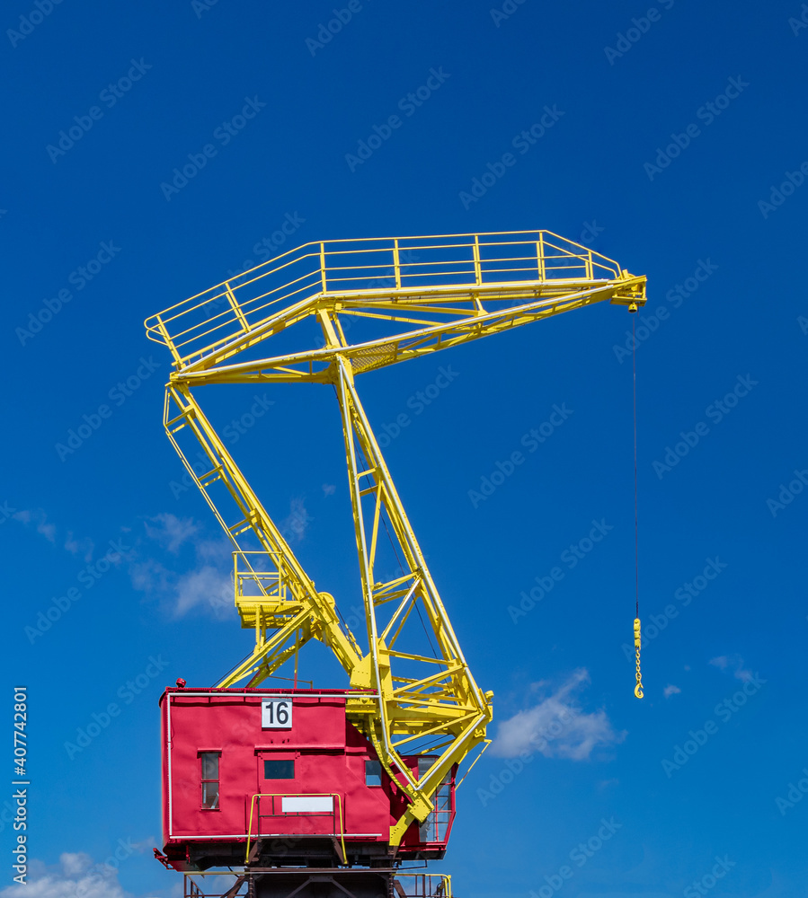 one colorful industrial crane on a blue sky background one colorful industrial crane on a blue sky background