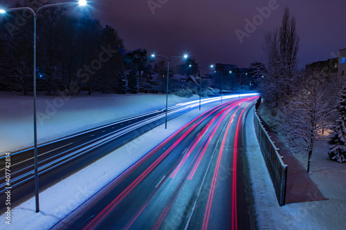 Платно Aerial view of a long exposure night shot of a busy freeway traffic motion near
