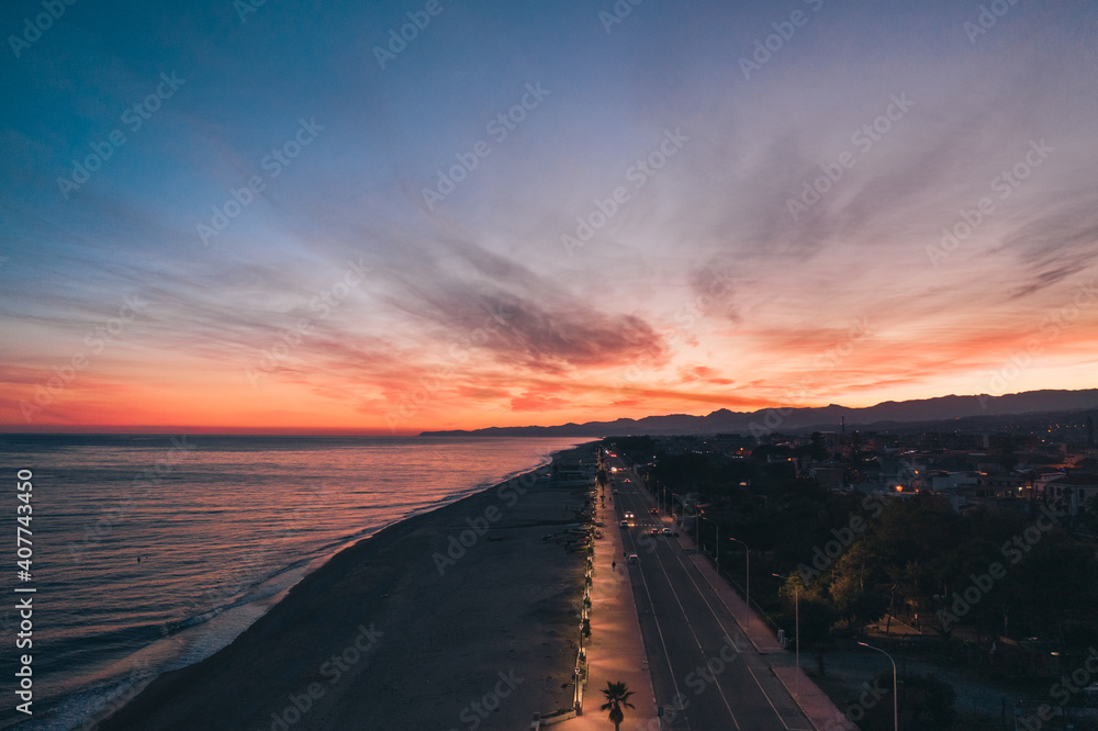 Città di Locri vista aerea notturna al tramonto, Calabria,.