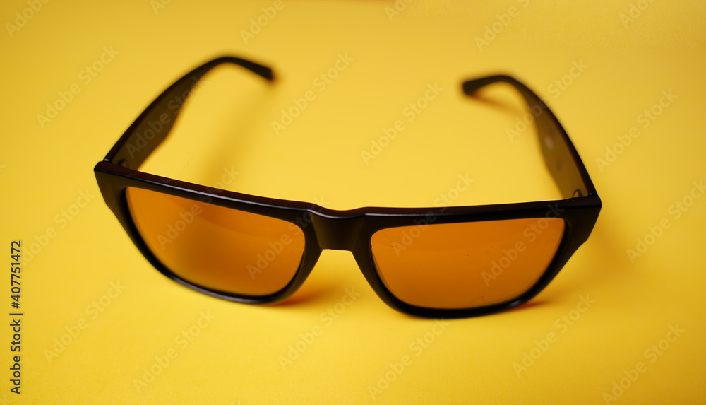 Close up of sunglasses on yellow background. Fashionable accessory for protection eyes from sun. Close up of sunglasses on yellow background. Fashionable accessory for protection eyes from sun.