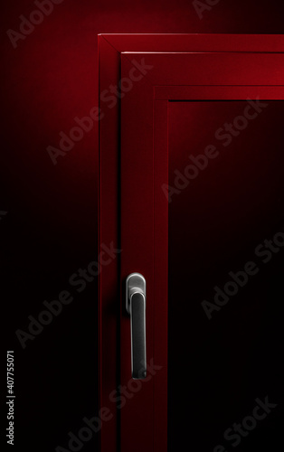 Detail of red aluminium window with handle on black background