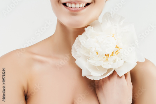 Close up of a beautiful smile Girl holding a fresh white flower near her face. Beautiful smile, healthy teeth